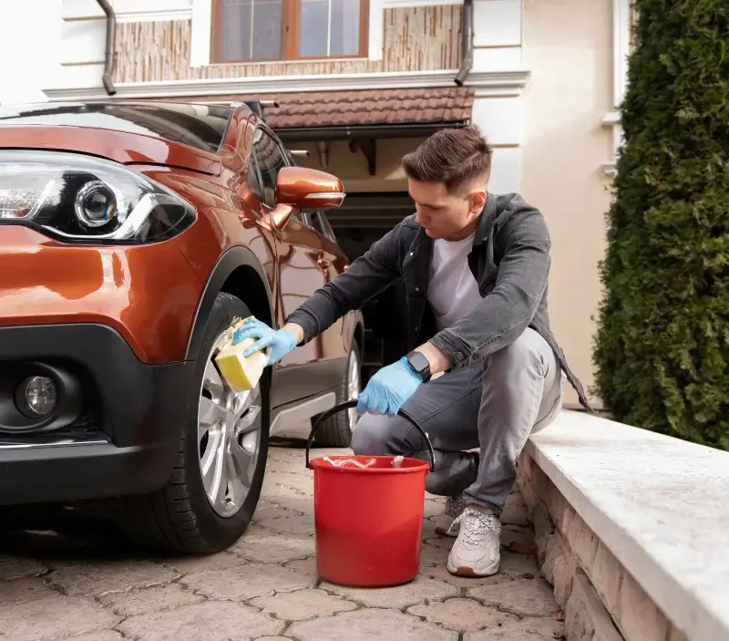 Lavage auto à domicile Val de Louyre et Caudeau : professionnel intervenant sur un véhicule
